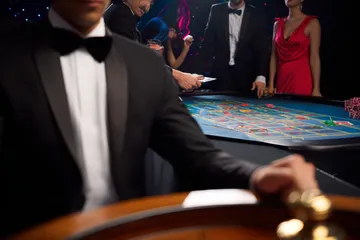 A professional dealer in a tuxedo greeting players at the roulette table, symbolizing the authentic live casino feel at LINEBED.